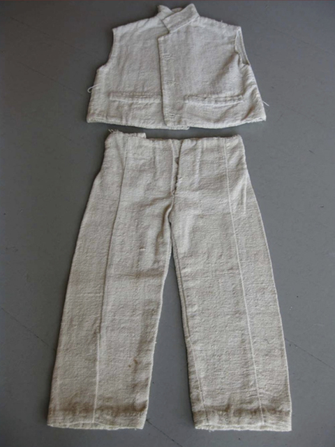A small, light-colored set of a sleeveless jacket and pants